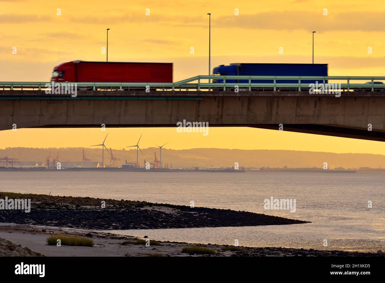 Lorries travelling on the M4 Second Severn Crossing, now called the Prince of Wales Bridge, from Aust side in England, UK. With Sunset. Stock Photo