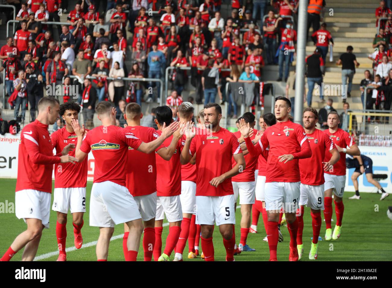 Die Freiburger Spieler präsentieren schon vor dem Anpfiff Teamgeist und klatschen sich beim WarmUp ab vor dem Spiel der 1. FBL: 21-22: 6. Sptg. SC Fre Stock Photo