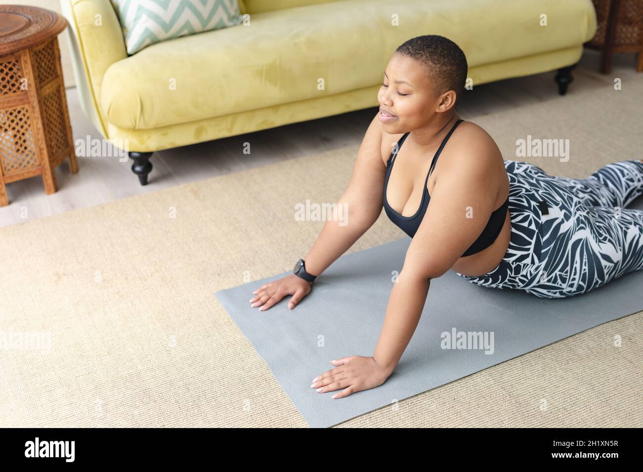 https://c8.alamy.com/comp/2H1XN5R/happy-african-american-plus-size-woman-practicing-yoga-on-mat-at-home-2H1XN5R.jpg