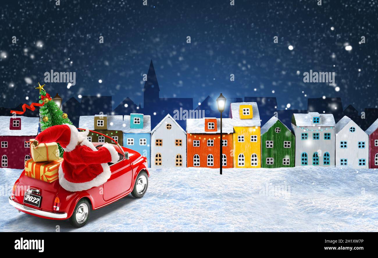 Christmas For The City 2022 Christmas 2022 Greeting Card. Santa Claus In Red Car Delivering Gift Boxes  And Christmas Tree In The Night Snowy City With Colorful Miniature Houses A  Stock Photo - Alamy