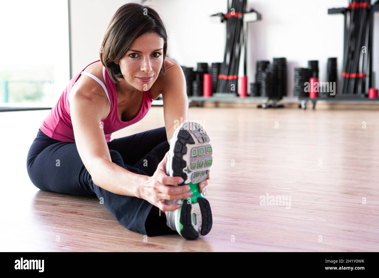 Healthy young woman exercising in a gym Stock Photo