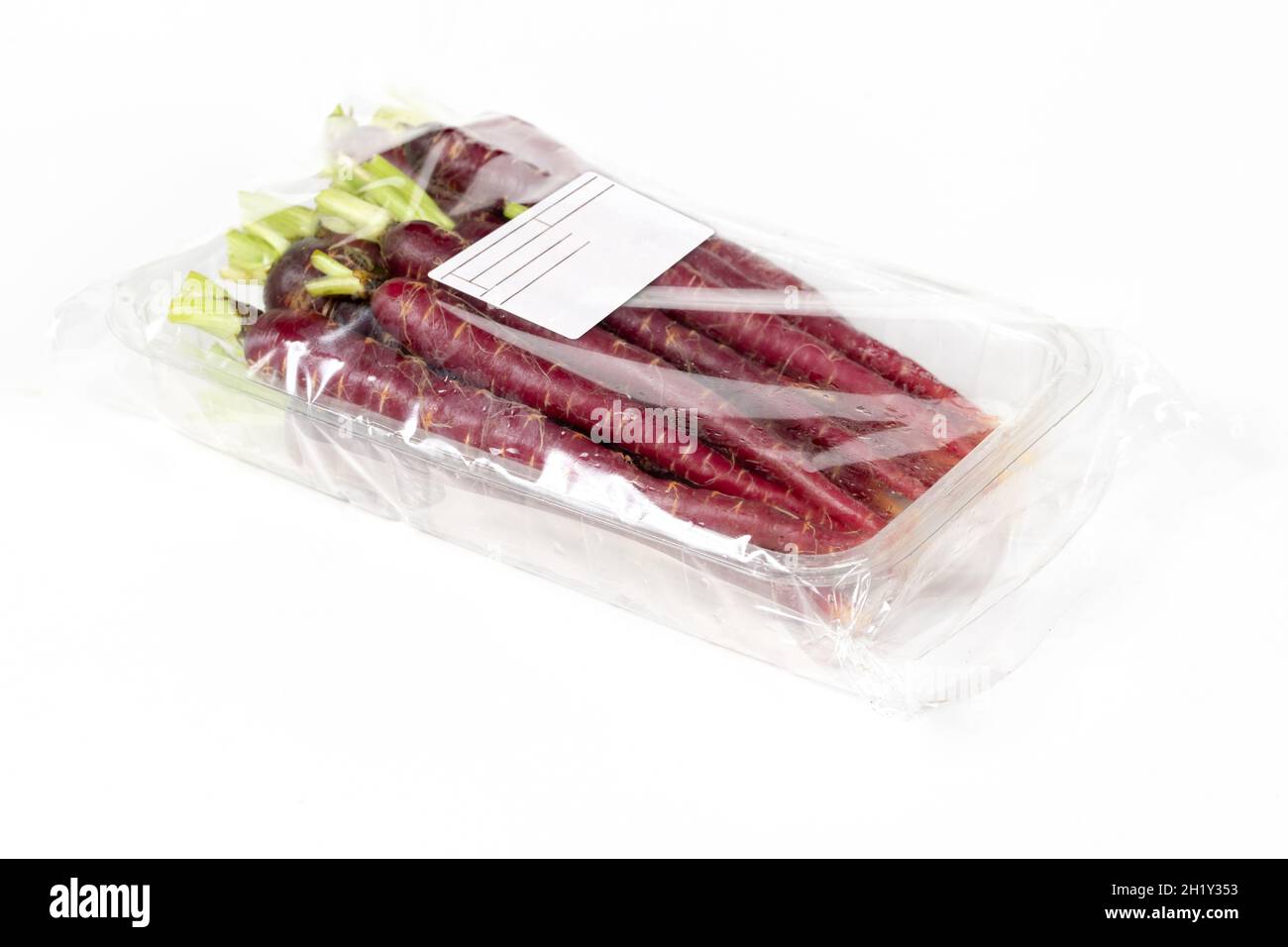 Mini red carrots in labeled packaging on a white background Stock Photo
