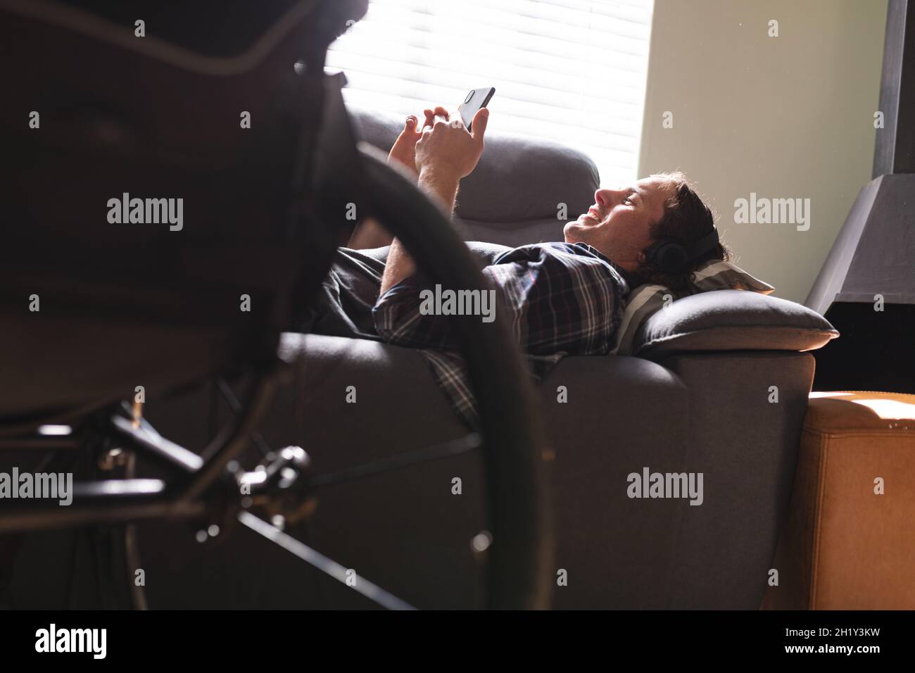 Caucasian disabled man using smartphone while lying on the couch at home Stock Photo
