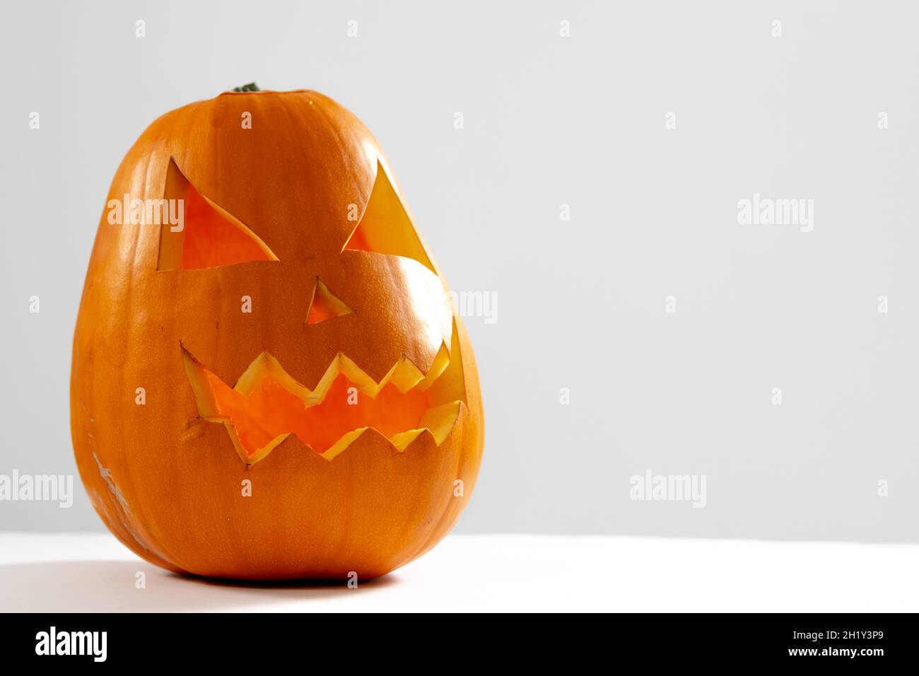 Composition of scary halloween carved orange pumpkin on white ...