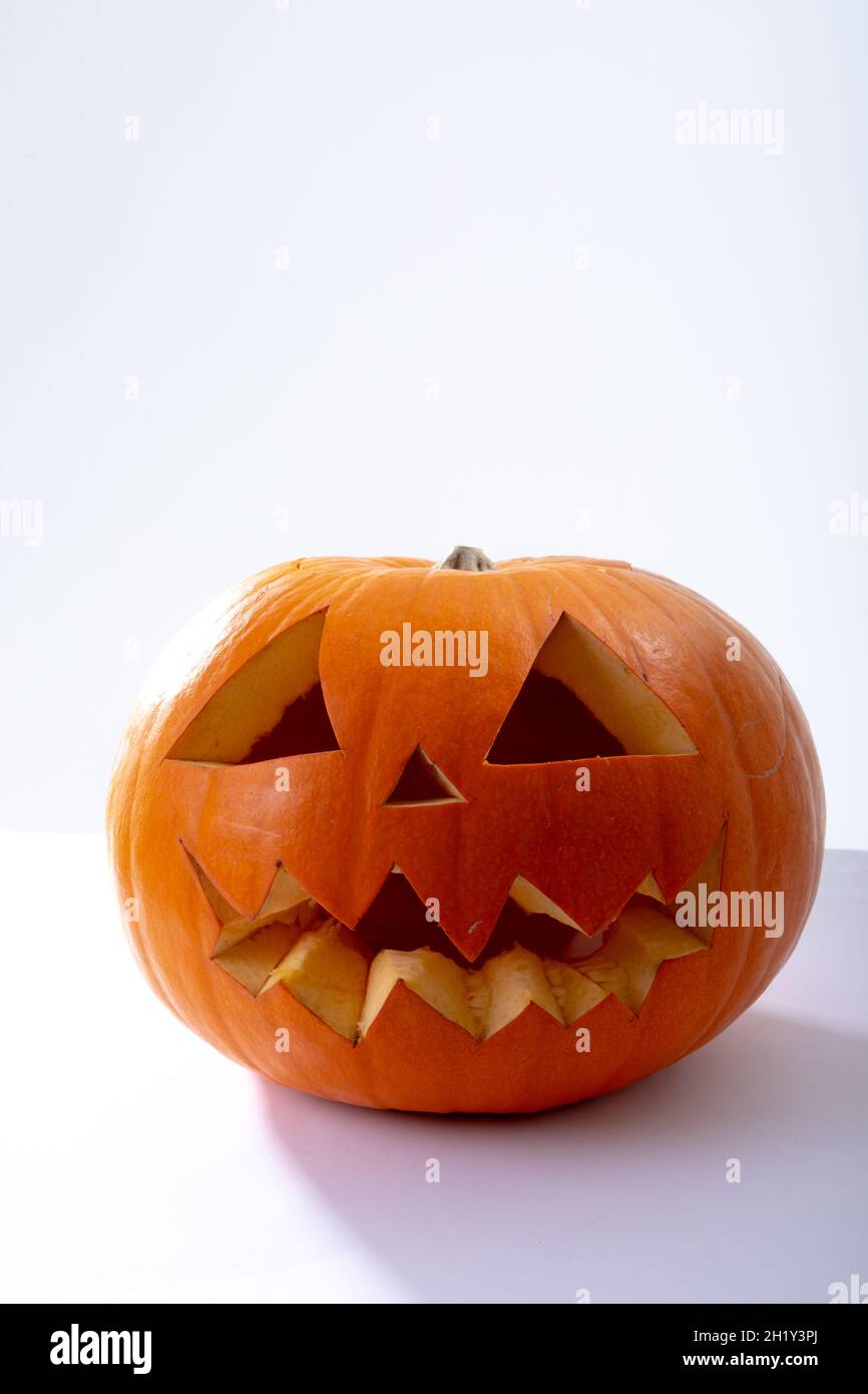 Composition of scary halloween carved orange pumpkin on white ...