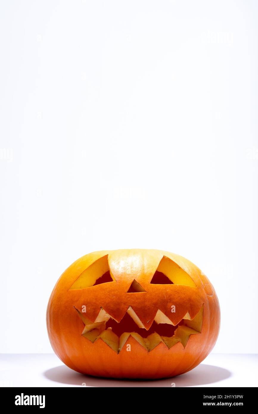Composition of scary halloween carved orange pumpkin on white ...