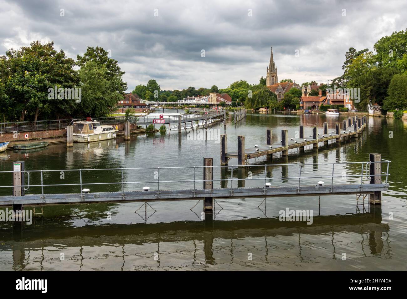 View of the River Thames towards Marlow from Marlow Lock, Buckinghamshire, with the weir, suspension bridge and All Saints church in the background. Stock Photo