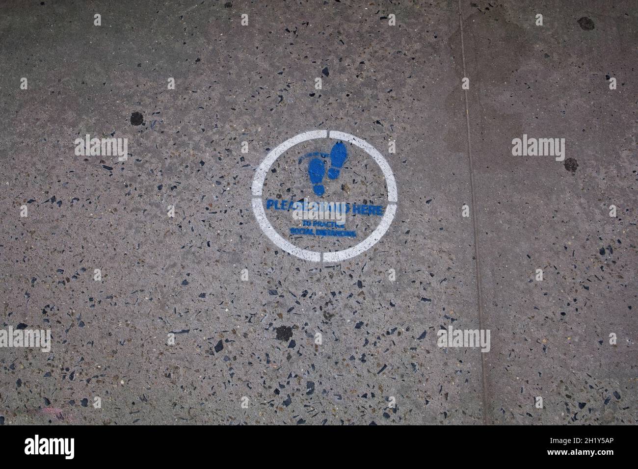 Sidewalk logo to request crowds practice social distancing Stock Photo