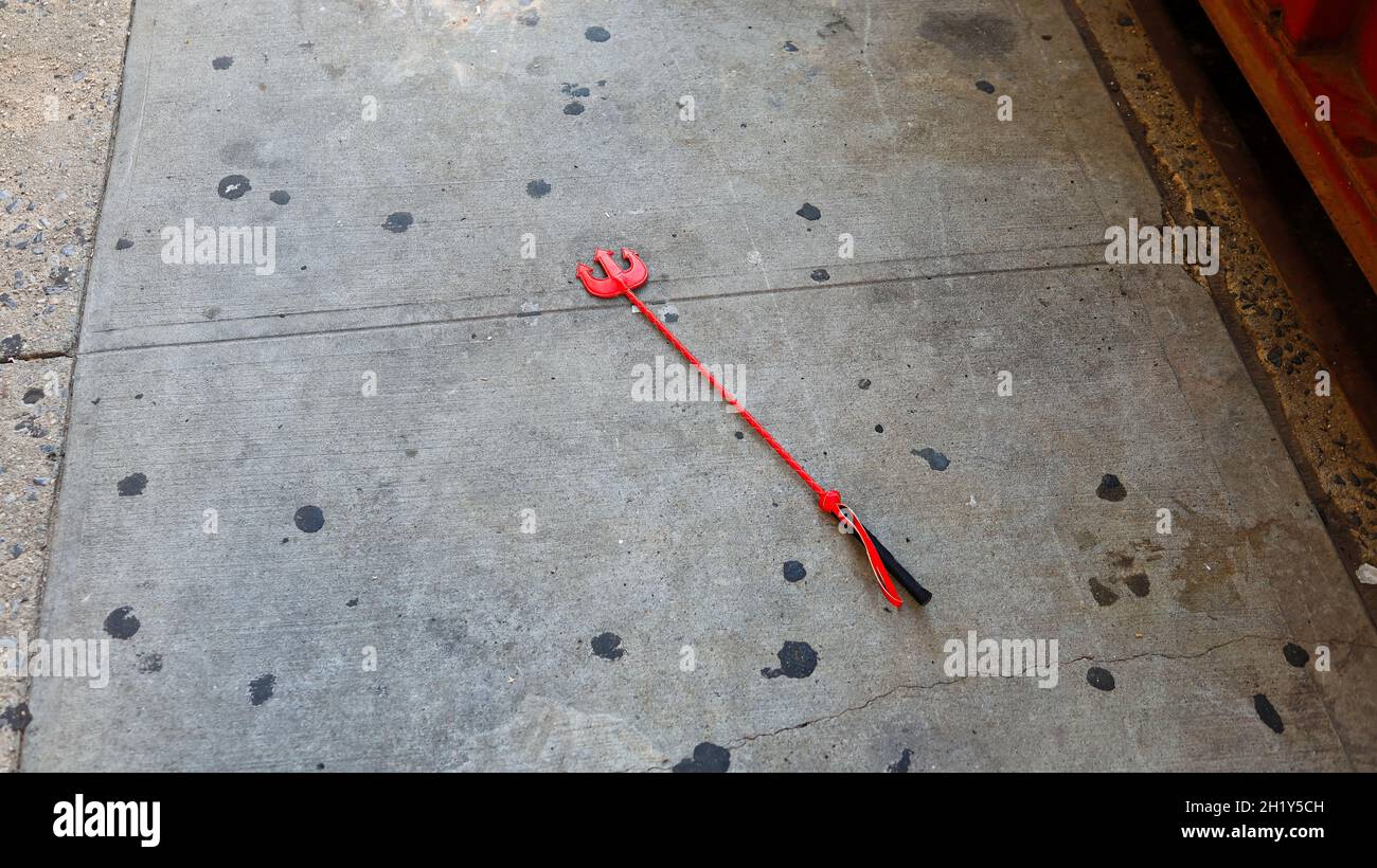 Small stick with harpoon at the end lying on sidewalk Stock Photo