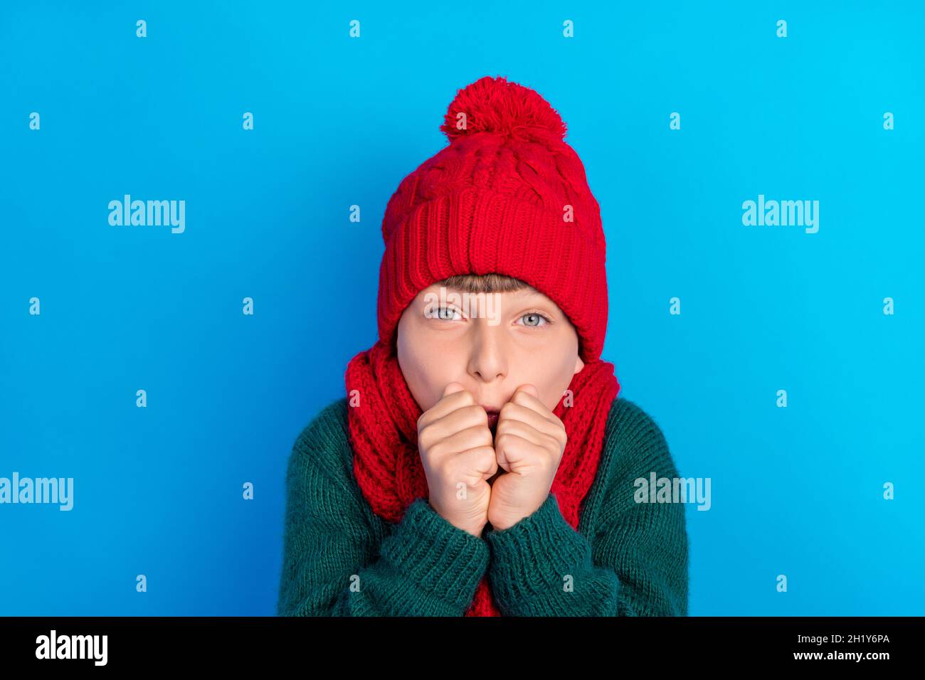 Photo portrait little boy wearing red headwear scarf trembling on frost isolated bright blue color background Stock Photo