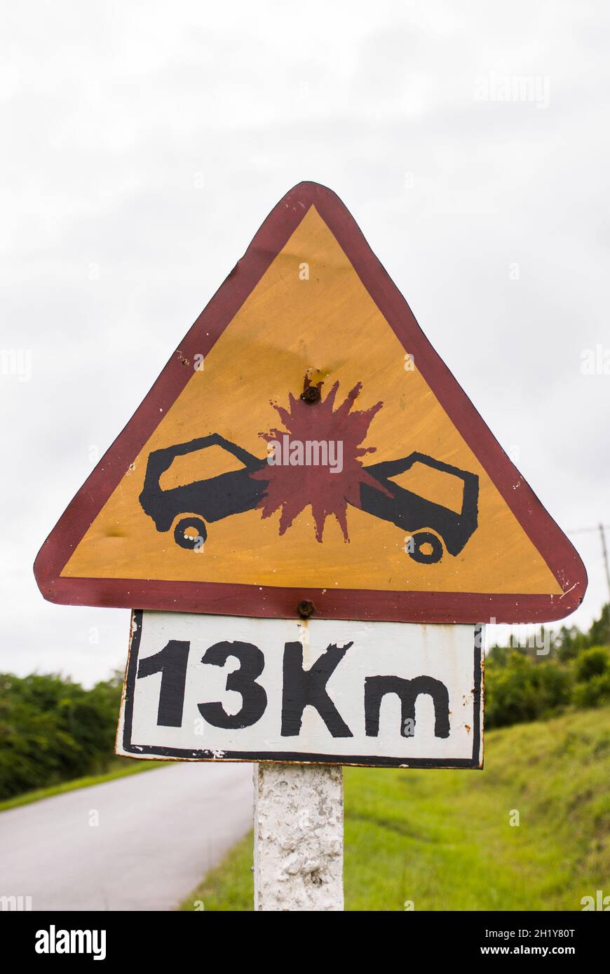 Comical road sign depicting head on collision between two cars resulting in large red explosion to warn of accident risk. Cuba. Stock Photo