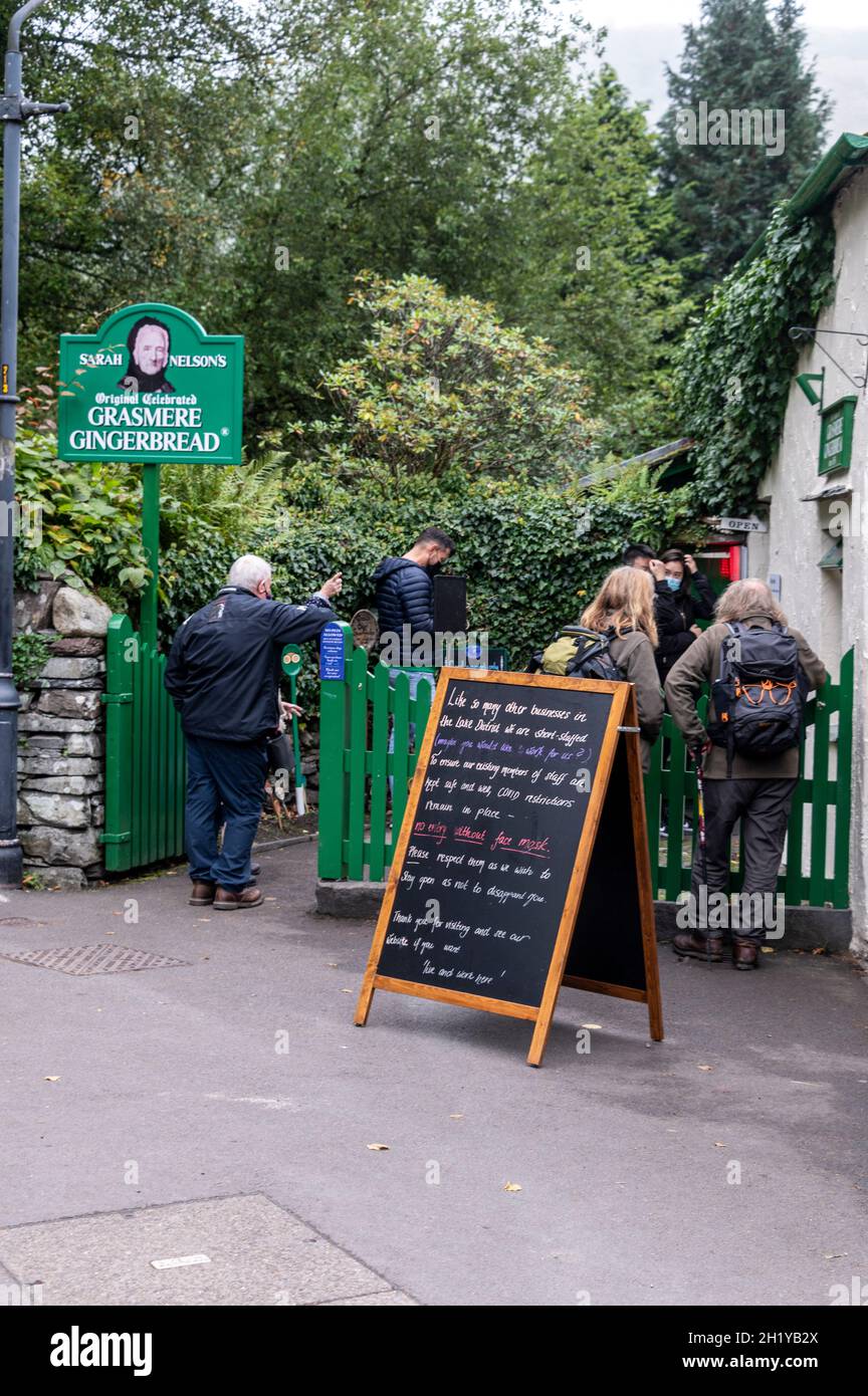 Visitors queue to see the making of Grasmere Gingerbread and buy its products in the small touristy village of Grasmere in the Lake District National Stock Photo