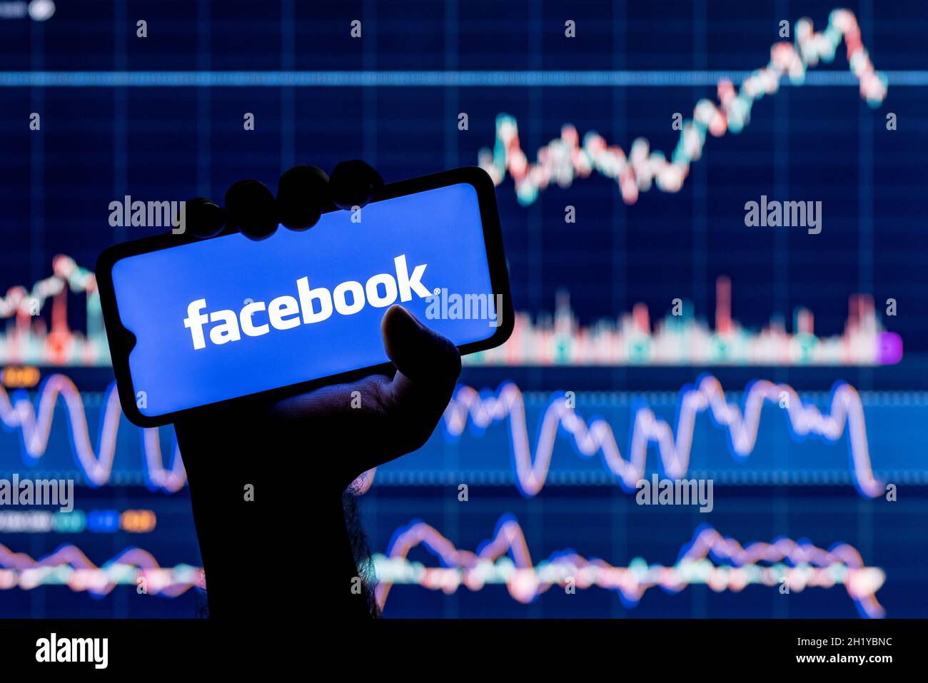 A smartphone with the facebook social network logo in hand. Facebook