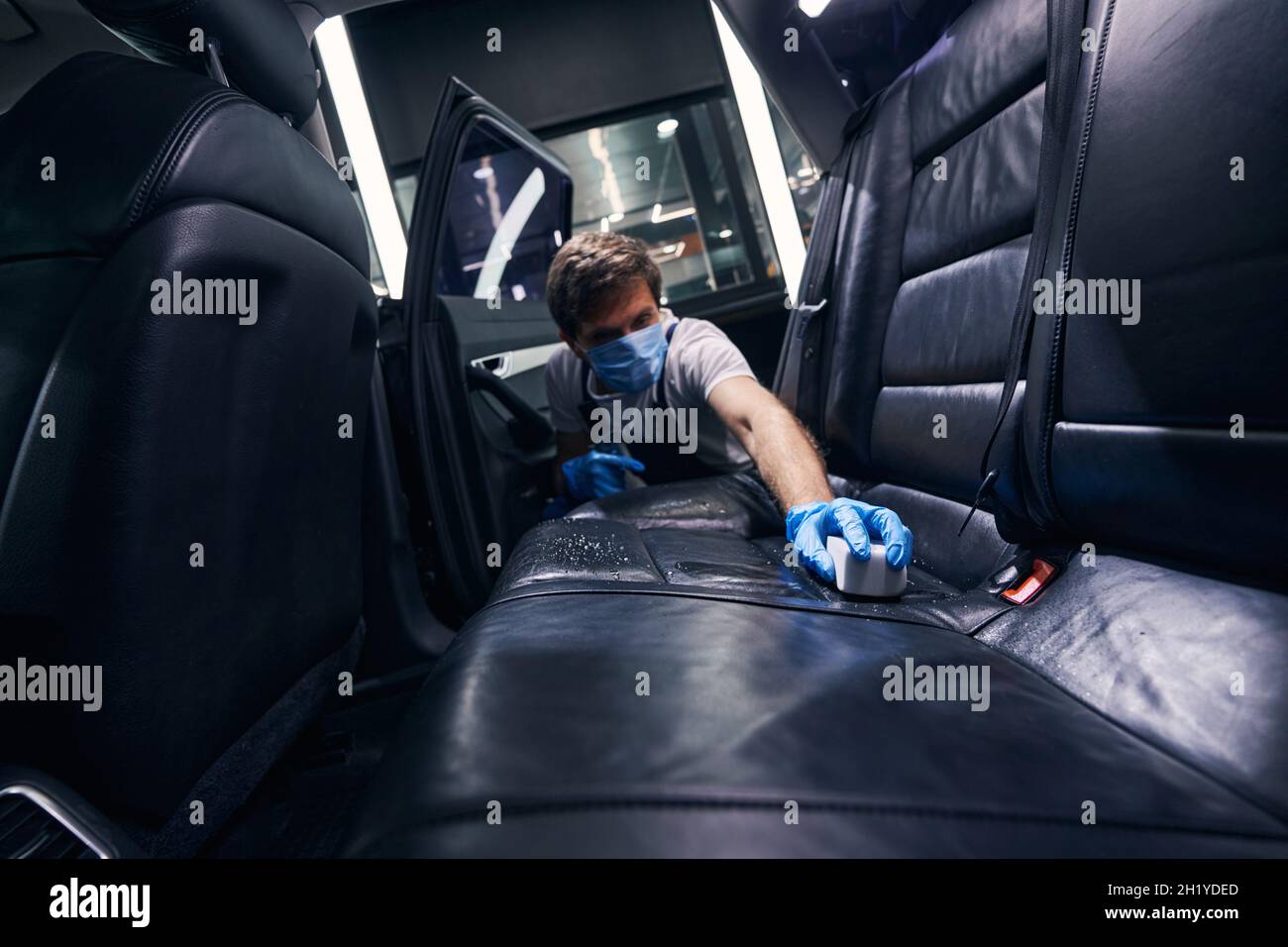 Man with sponge cleaning car seats surface Stock Photo