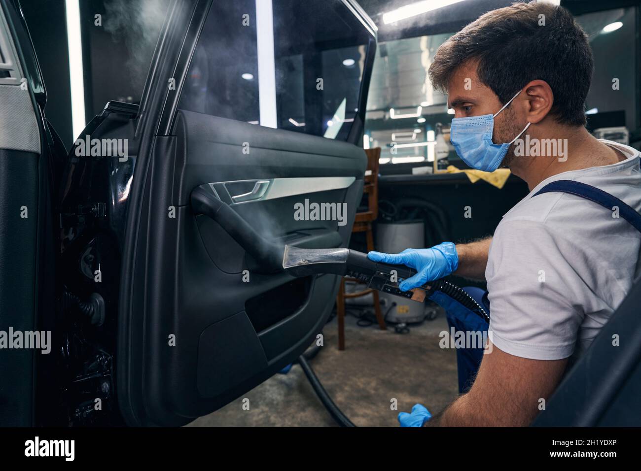 Car mechanic during auto detailing steam cleaning door Stock Photo Alamy