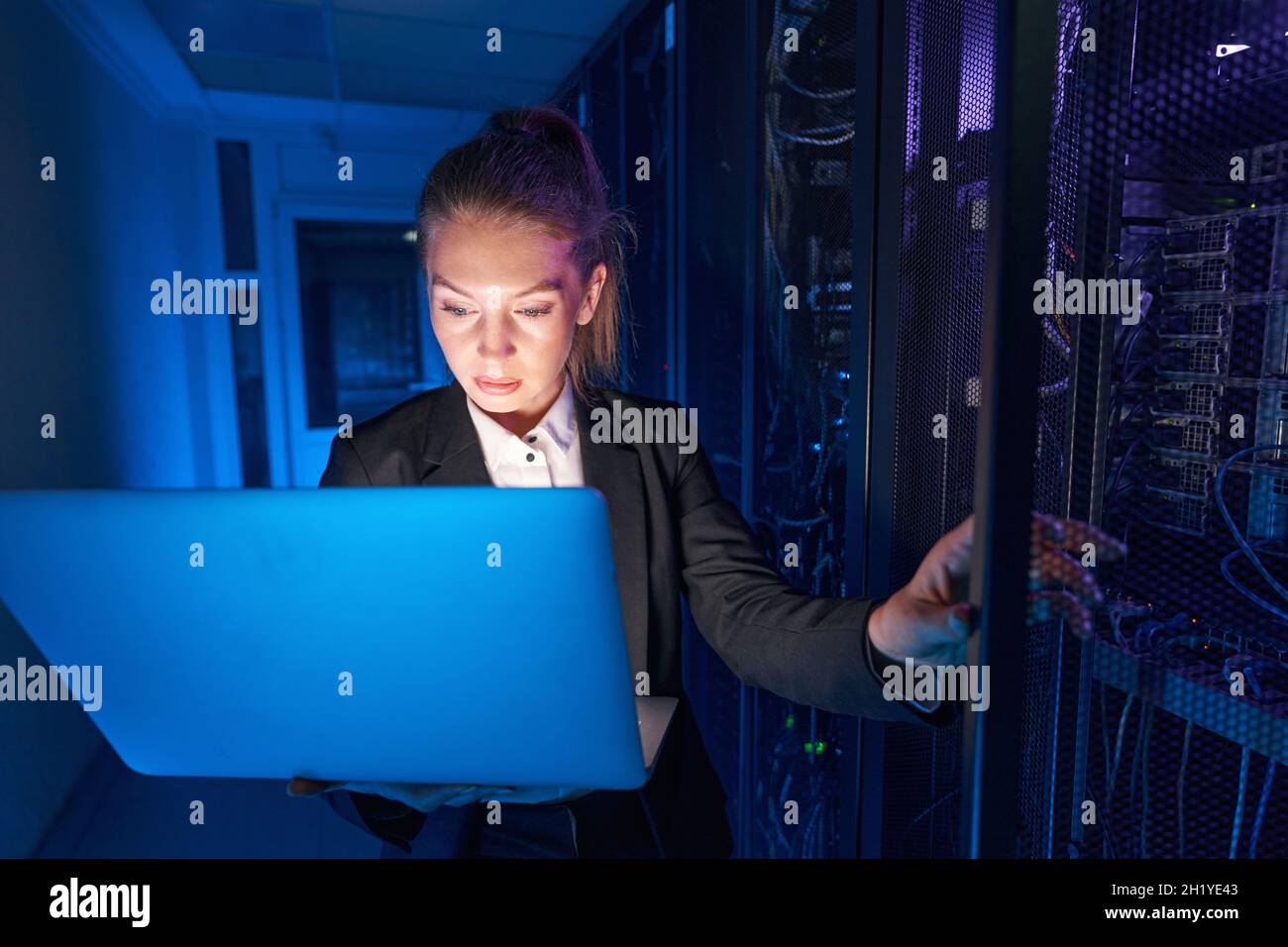 System technician using laptop to analyze server Stock Photo