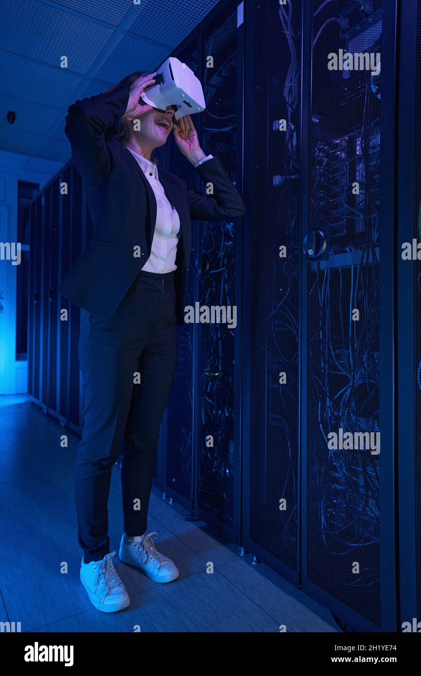 Female in VR glasses working at data center Stock Photo