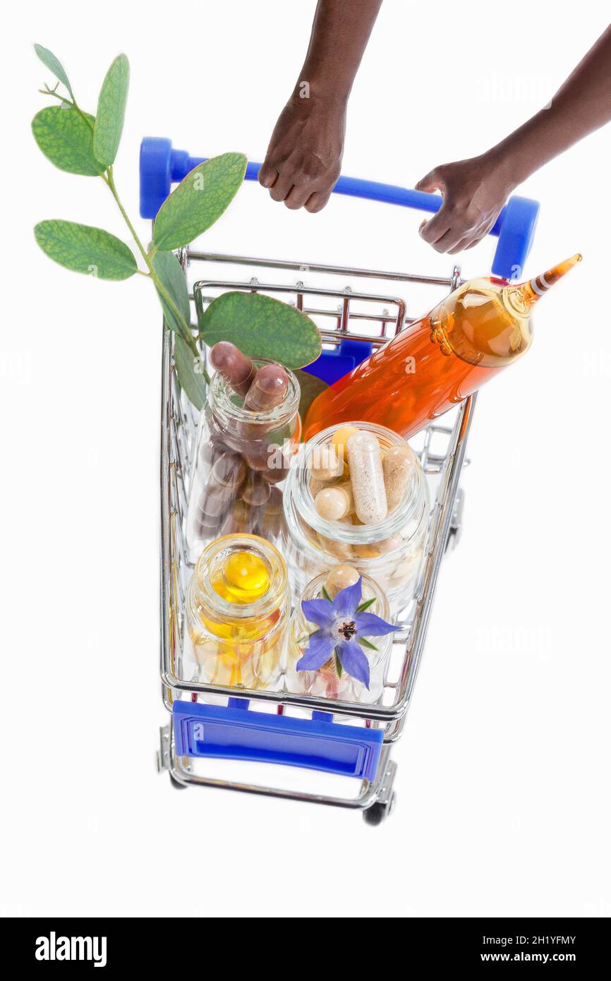 Hands pushing a shopping trolley full of pharmaceutical products Stock Photo