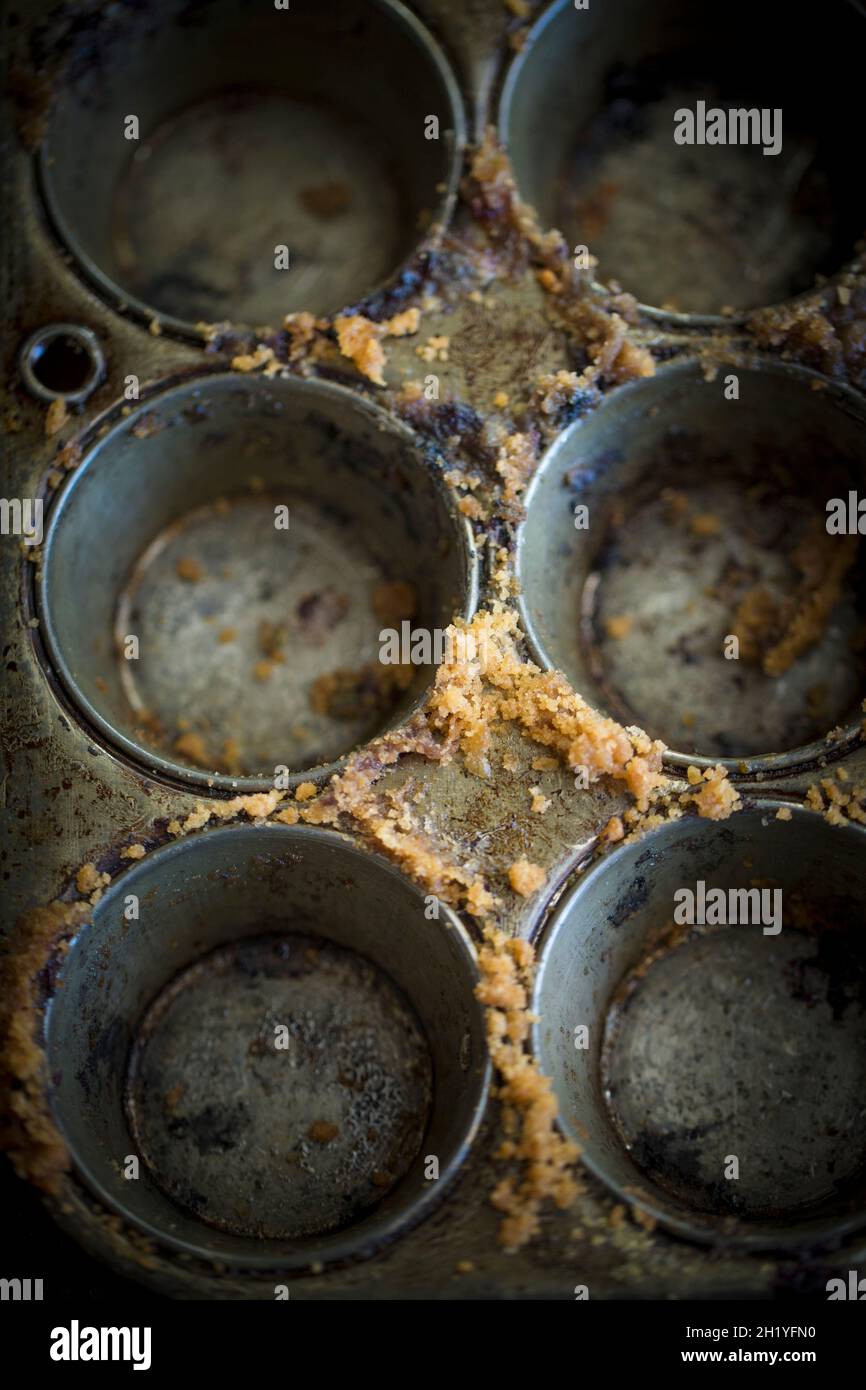 An empty muffin tins with cake crumbs Stock Photo Alamy