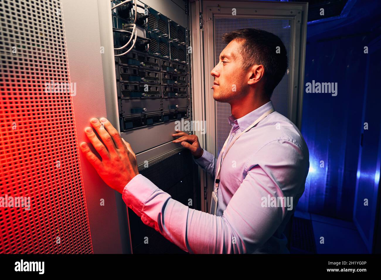 Serious concentrated IT technician inspecting hardware equipment Stock Photo