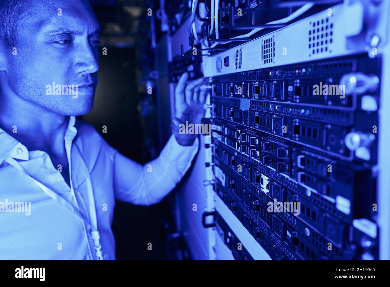 Engineer performing visual inspection of server hardware Stock Photo