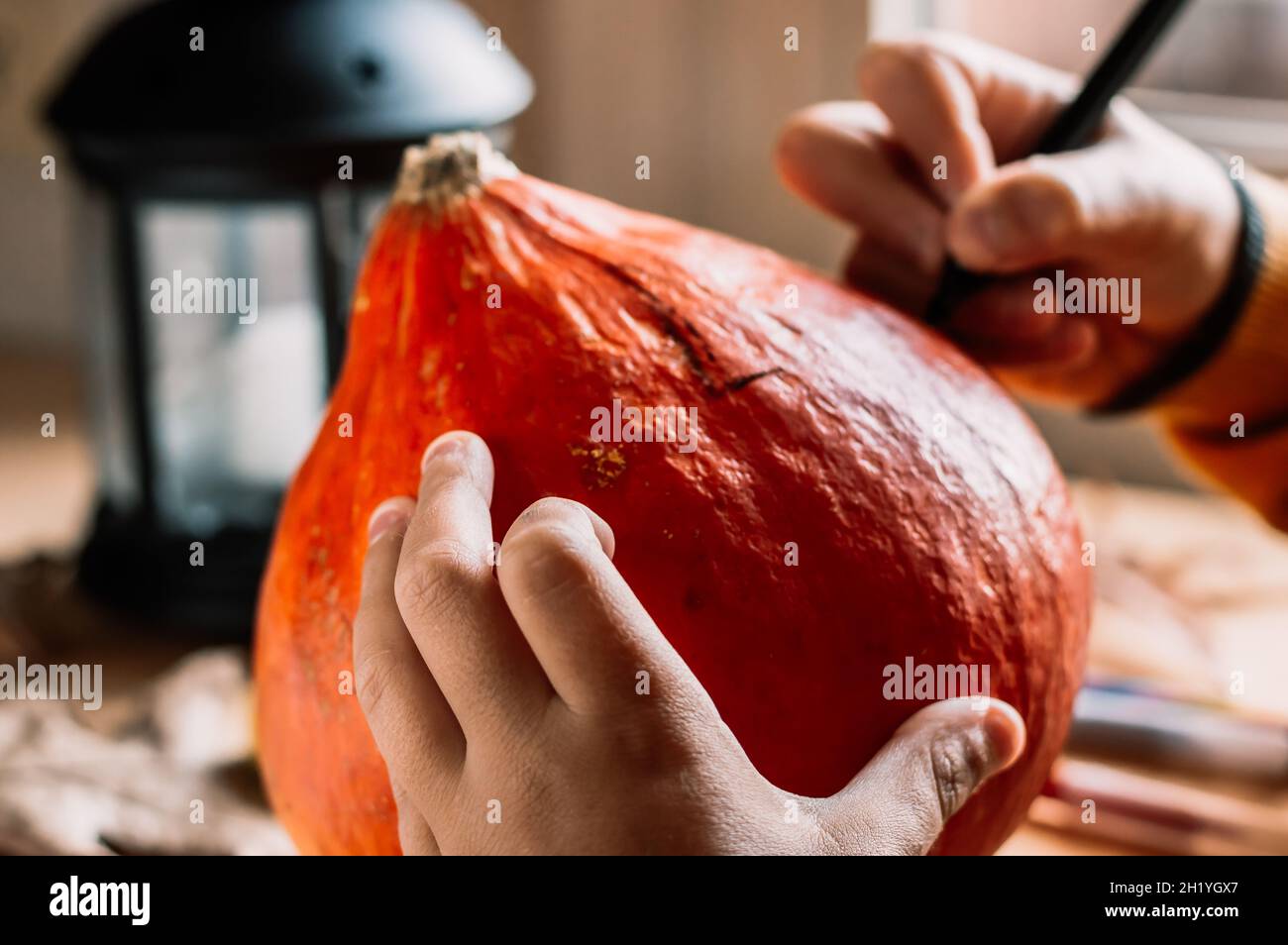 the child's hands draw on the monster pumpkin,preparation for Halloween. Stock Photo