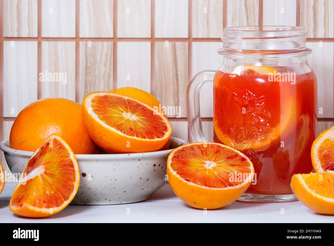 An arrangement of blood oranges and a carafe of blood orange juice