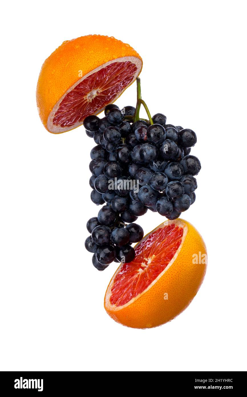 Dark blue grape with red grapefruit isolated on white background Stock Photo