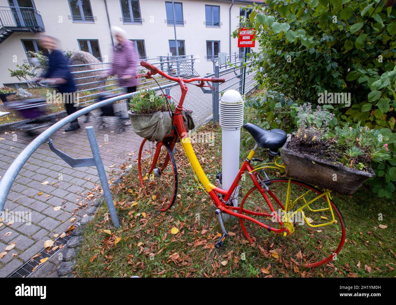 Bad Doberan, Germany. 19th Oct, 2021. Two residents leave the senior center 'Am Tempelberg' of the operator Volkssolidarität. (Long exposure shot) Several residents of the facility have died in connection with a Corona outbreak. In the past two weeks, 66 of the 83 residents at the residential care facility have tested positive for the corona virus. Credit: Jens Büttner/dpa-Zentralbild/dpa/Alamy Live News Stock Photo