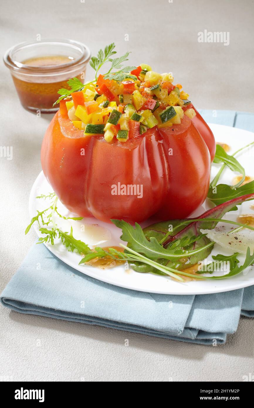 A beefsteak tomato filled with vegetables Stock Photo