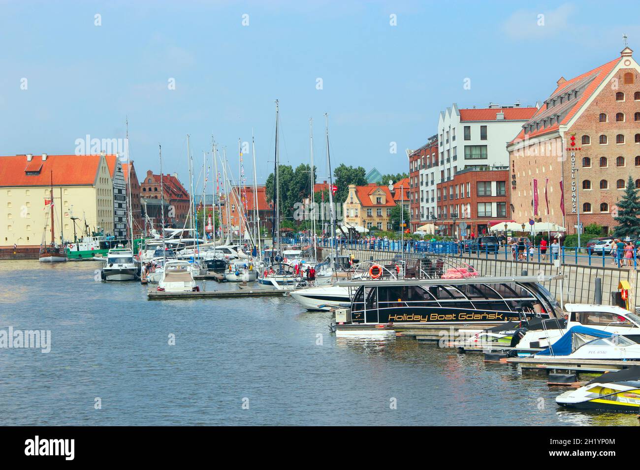 Beautiful quay with moored ships in Gdansk. Beautiful views of the river and many tourists in Gdansk. Many tourists walk around beautiful tourist Poli Stock Photo
