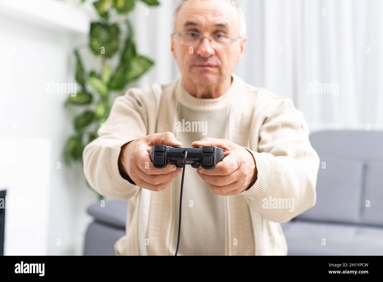 Portrait of elderly man playing video games with joystick Stock Photo -  Alamy, image size:1300x956