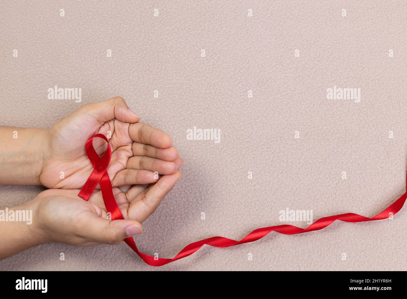 Hand Red Ribbons Hand holding a red awareness ribbon on a background with copy space ...