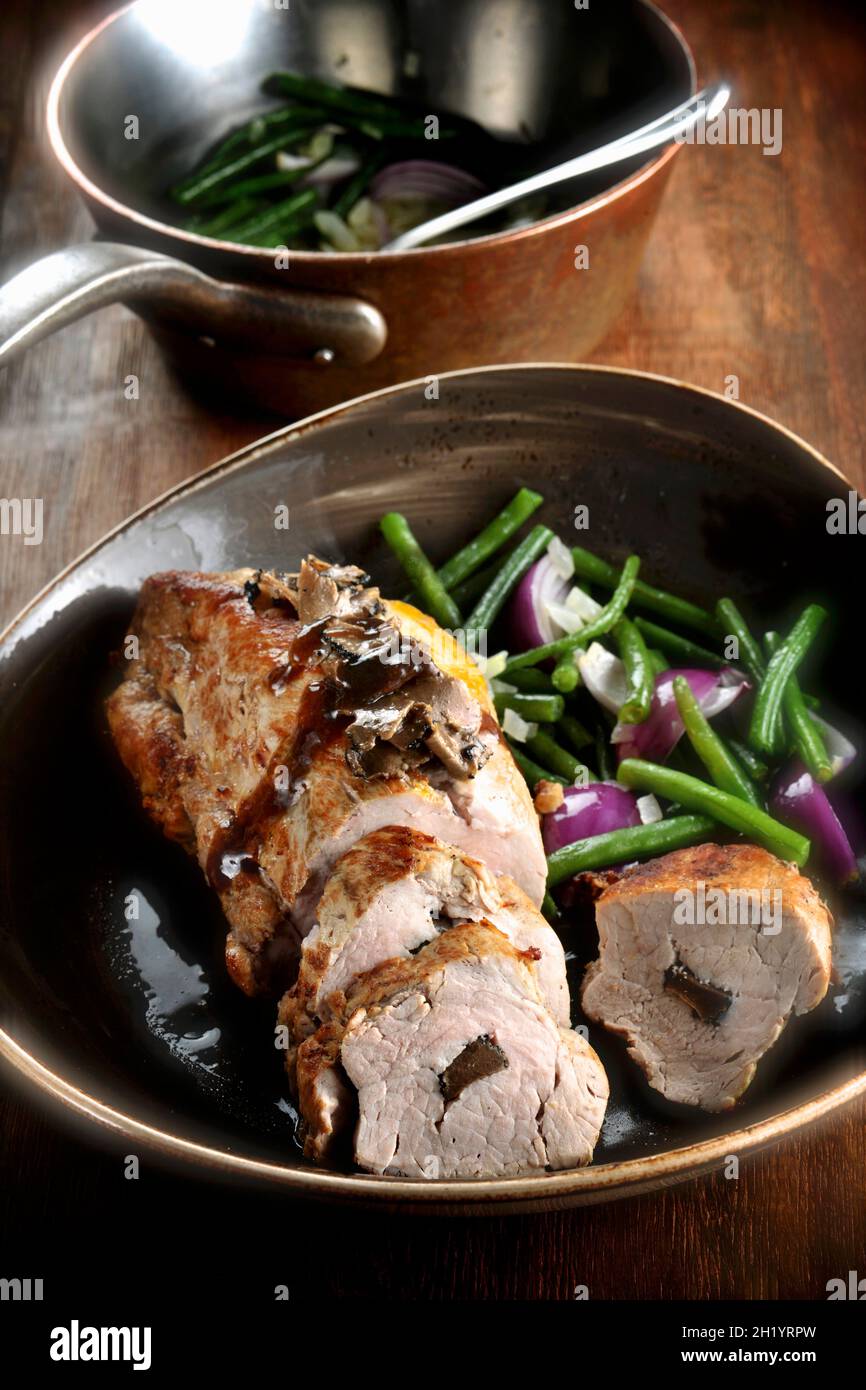 Stuffed roast pork with onions and beans Stock Photo