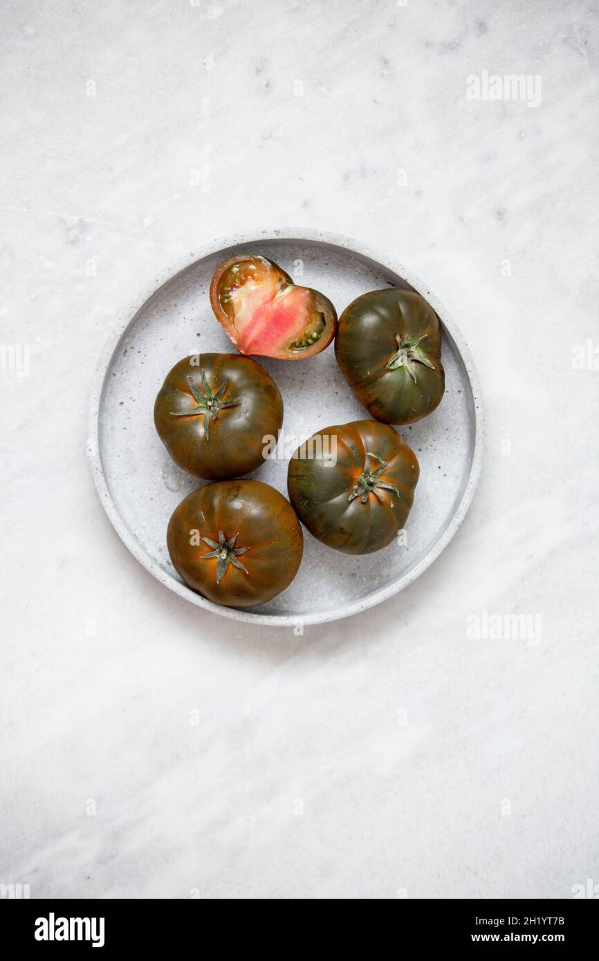 Organic Tomato 'Marmande black' on marble backgroun Stock Photo