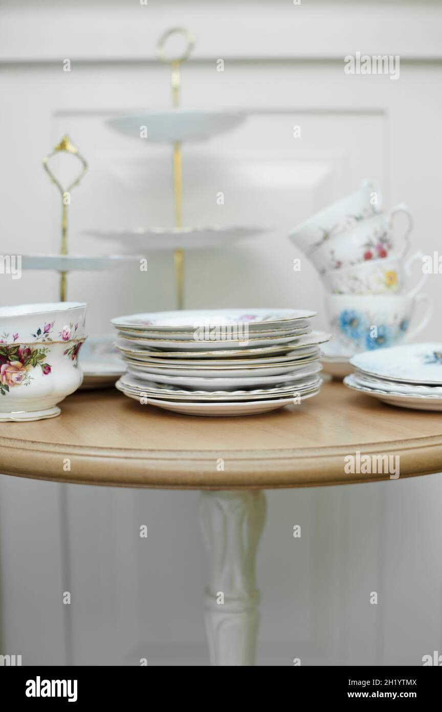 Vintage crockery (plates, cups and a cake stand) on a table Stock Photo