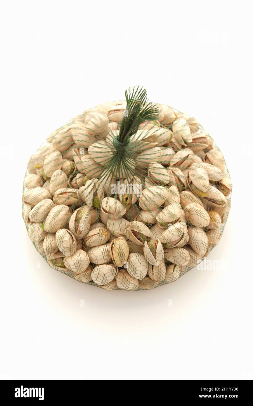 A bag of pistachios on a white surface Stock Photo Alamy