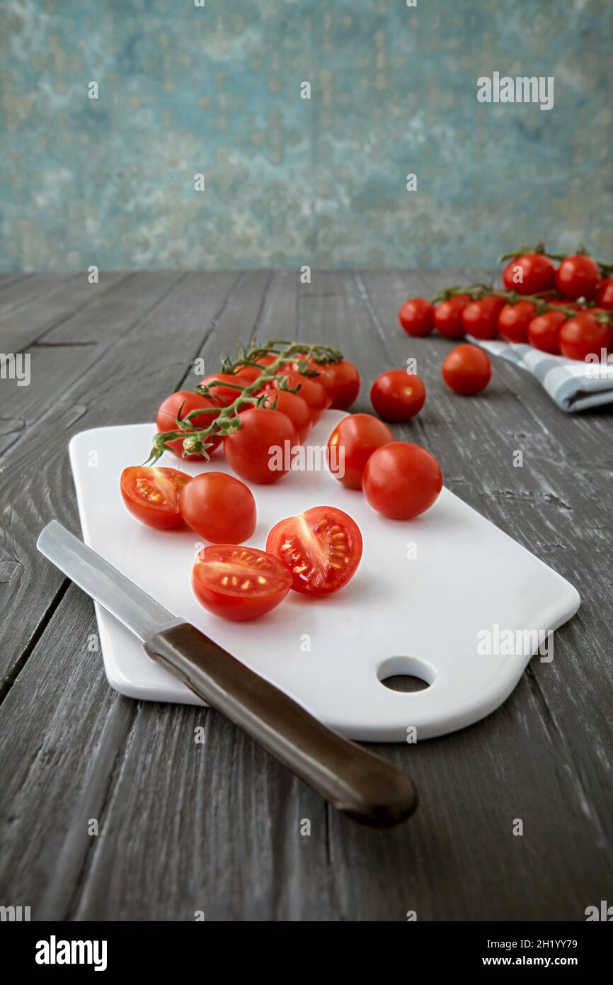 Cherry tomatoes on a chopping board, whole and halved Stock Photo - Alamy