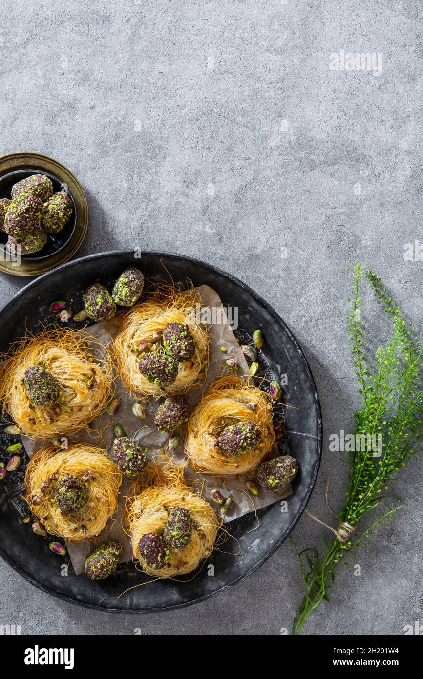 Easter eggs coated in dates, cocoa and pistachios in angel hair pasta nests Stock Photo