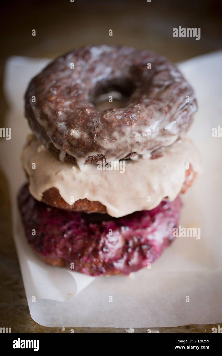 Three donuts with different glazes, stacked Stock Photo Alamy