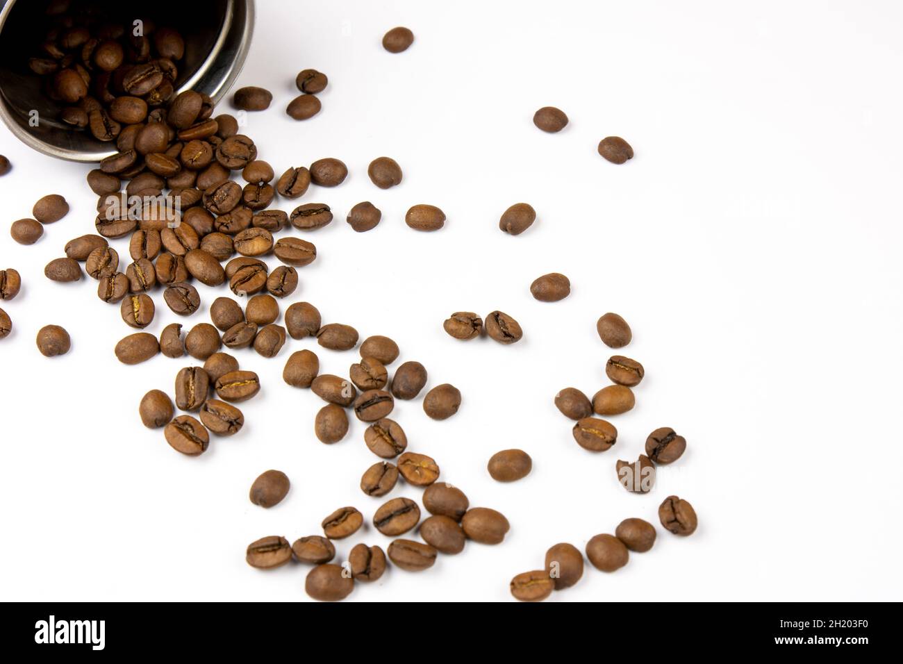 Roasted coffee beans on a white background. Overturned coffee can