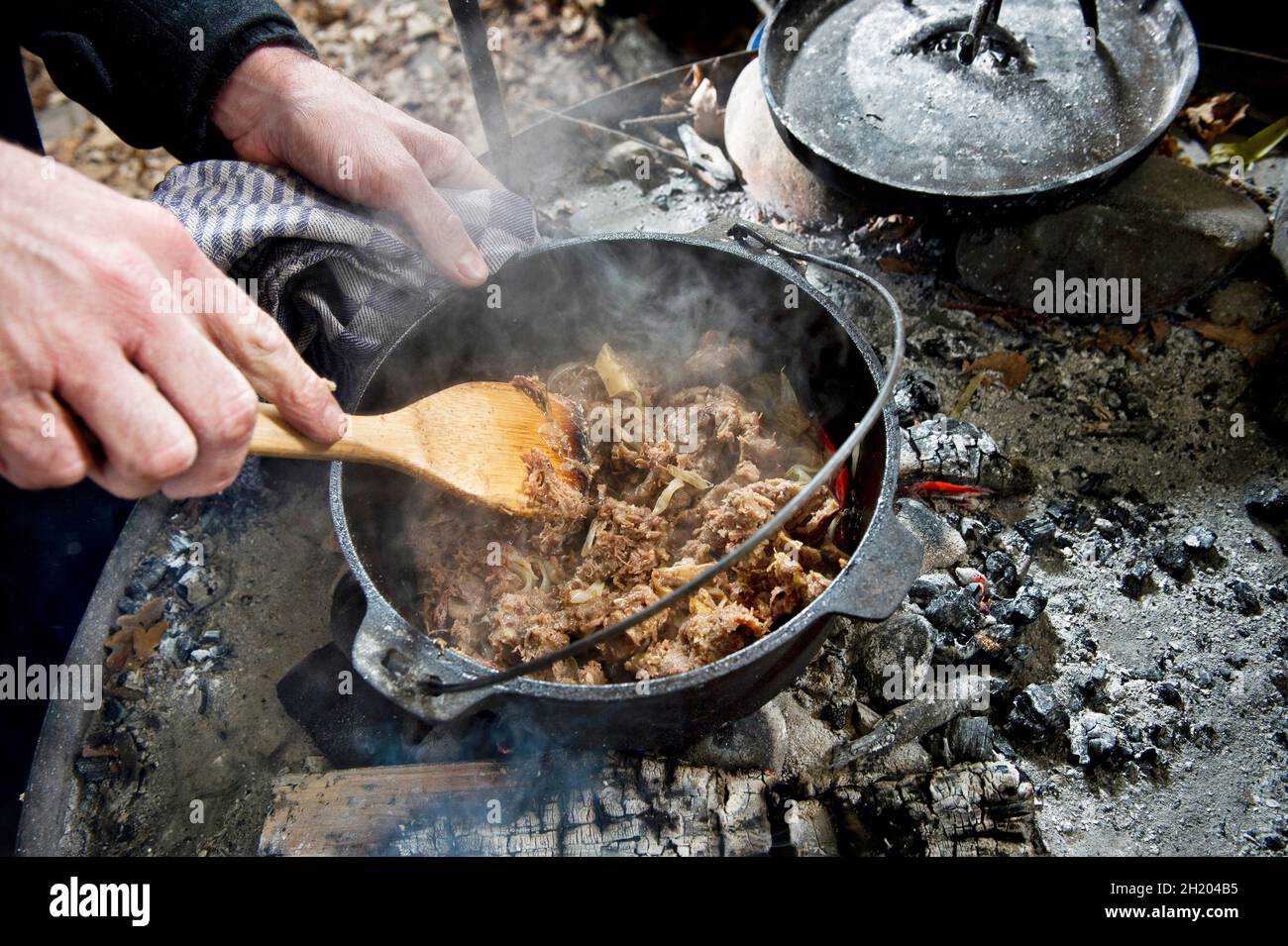 How to make a meat dish in a Dutch oven over a fire place Stock Photo