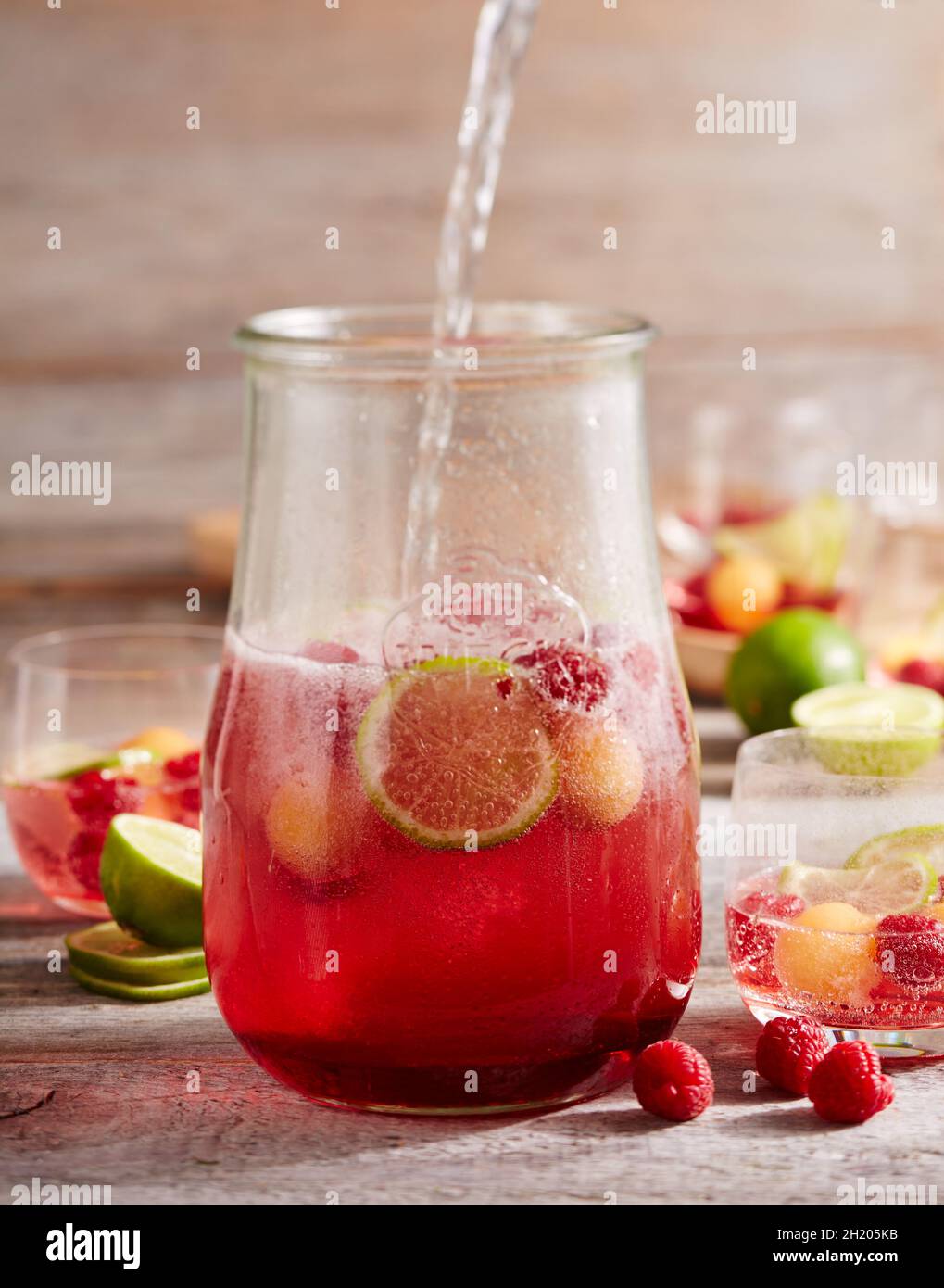 Raspberry and melon punch with champagne and limes in a jar Stock Photo