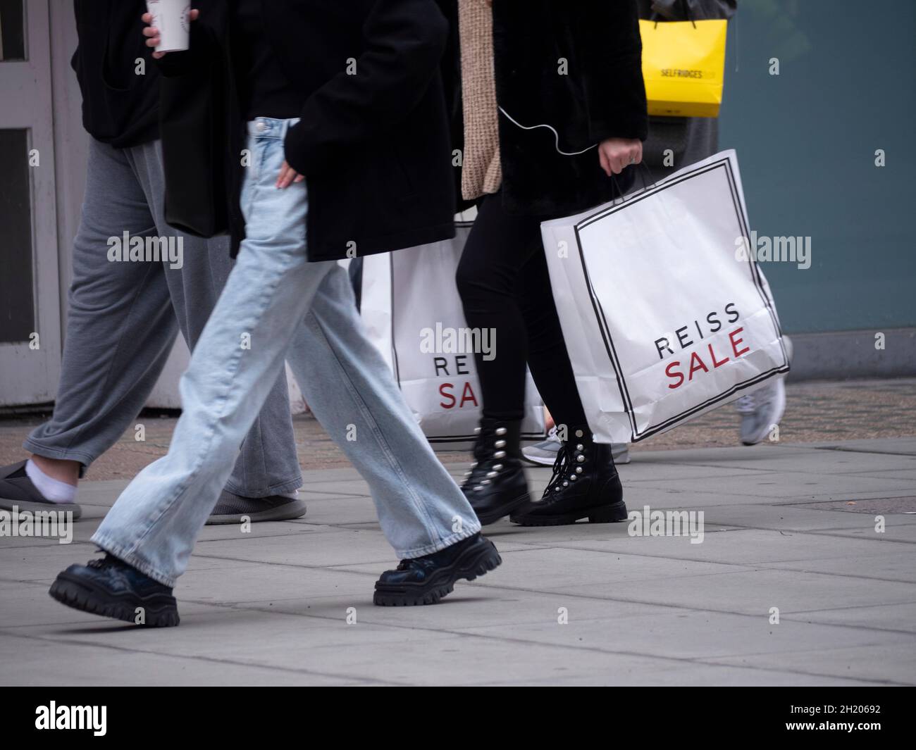 Rich poor divide inequality, Oxford Street London shopper holding a Reiss sale bag Reiss is aBritish fashion brand and retail store chain Stock Photo