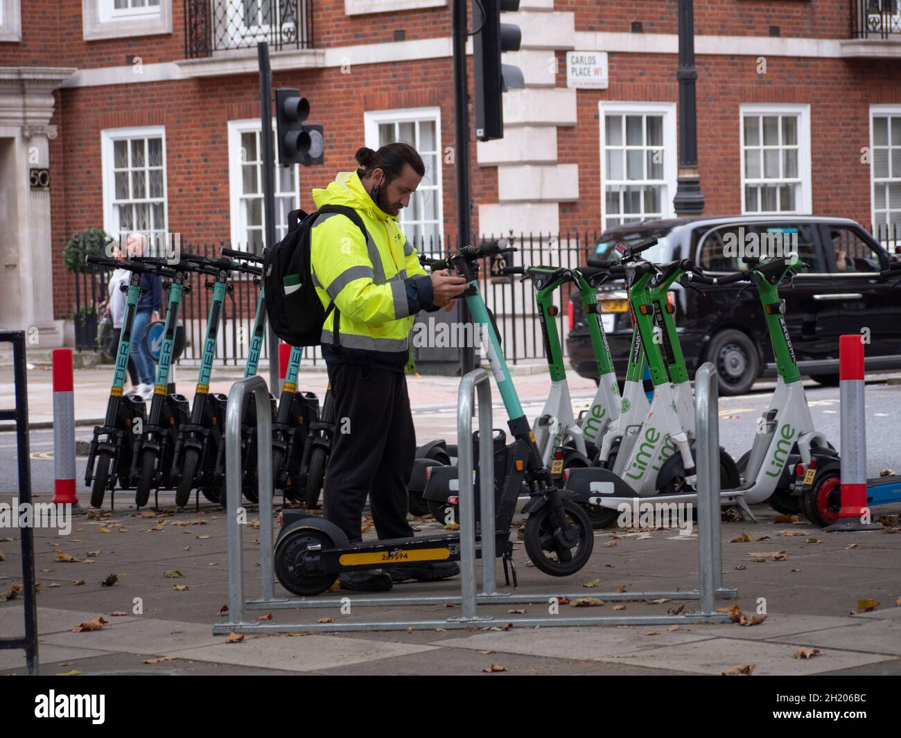 Tier and Lime Electric Scooters for hire in Mayfair London street Stock Photo Alamy