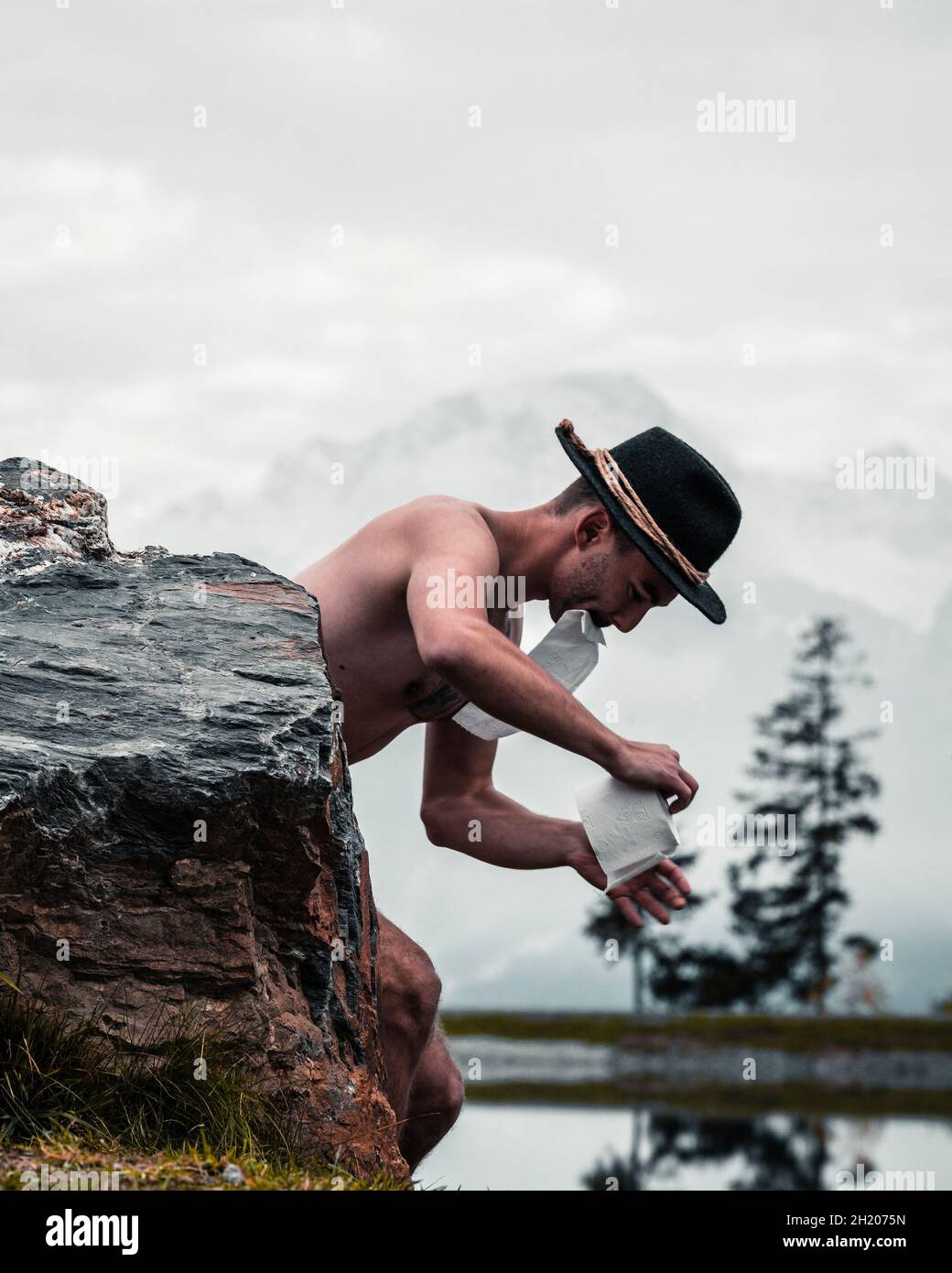 Funny photo of a man doing his business in the nature. Stock Photo