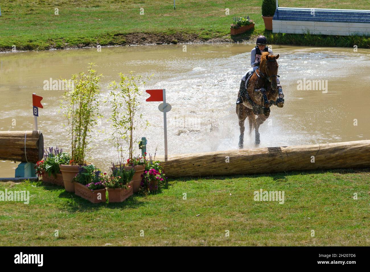 Horse and rider takling the cross country course and water jumps at an eventing competition in Gloucestershire, UK, in 2018. Stock Photo