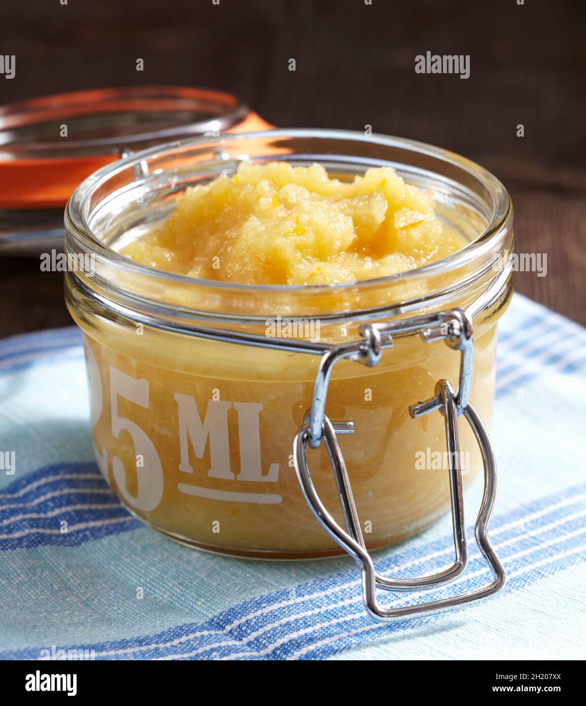 Apple and orange sauce with horseradish and vinegar in a fliptop jar