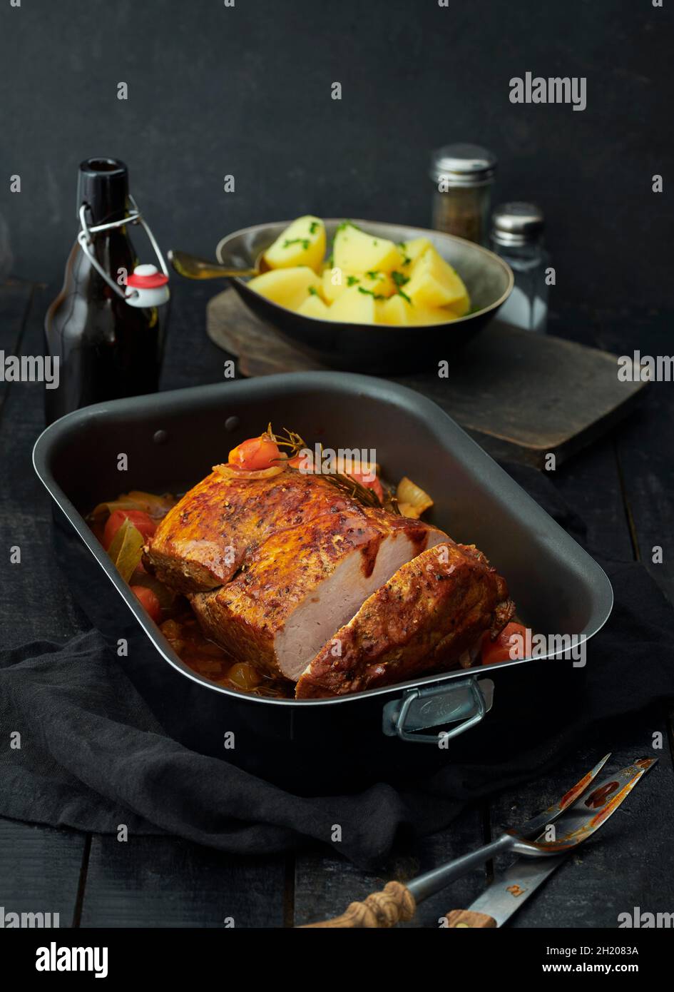 Roast pork in baking tin with parsley potatoes Stock Photo Alamy