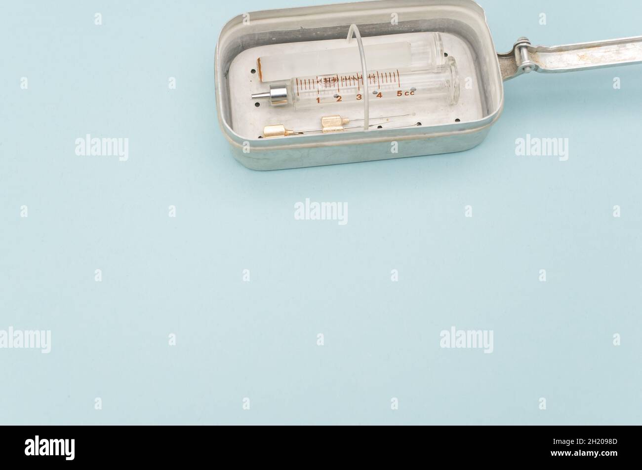 isolated sterilized glass injection syringe in a box on a blue Stock